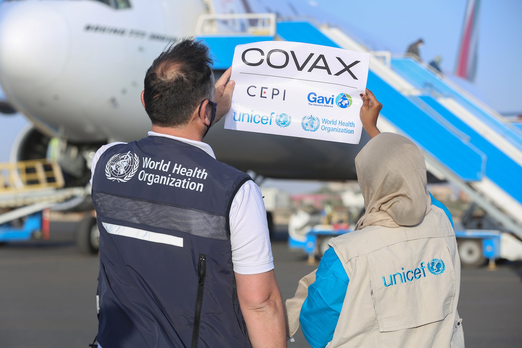 Staff from UNICEF and WHO hold a COVAX sticker upon the delivery of the COVID-19 vaccines at Khartoum International Airport in Sudan. Sudan received the first delivery of COVID-19 vaccines with over 800,000 doses on March 3, 2021.