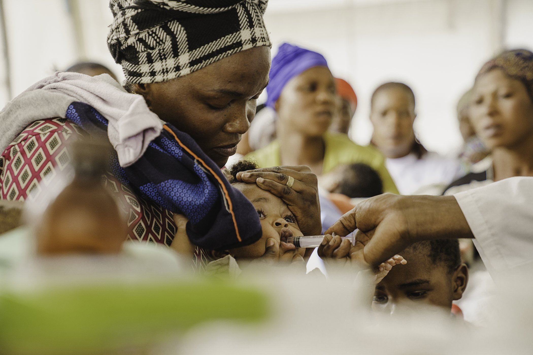Stéphanie Masika holds her 7-month-old daughter, Altheis, as she receives routine vaccinations,  including protection against measles, polio, and tuberculosis, at a health center in Goma, DR Congo, May 2025.