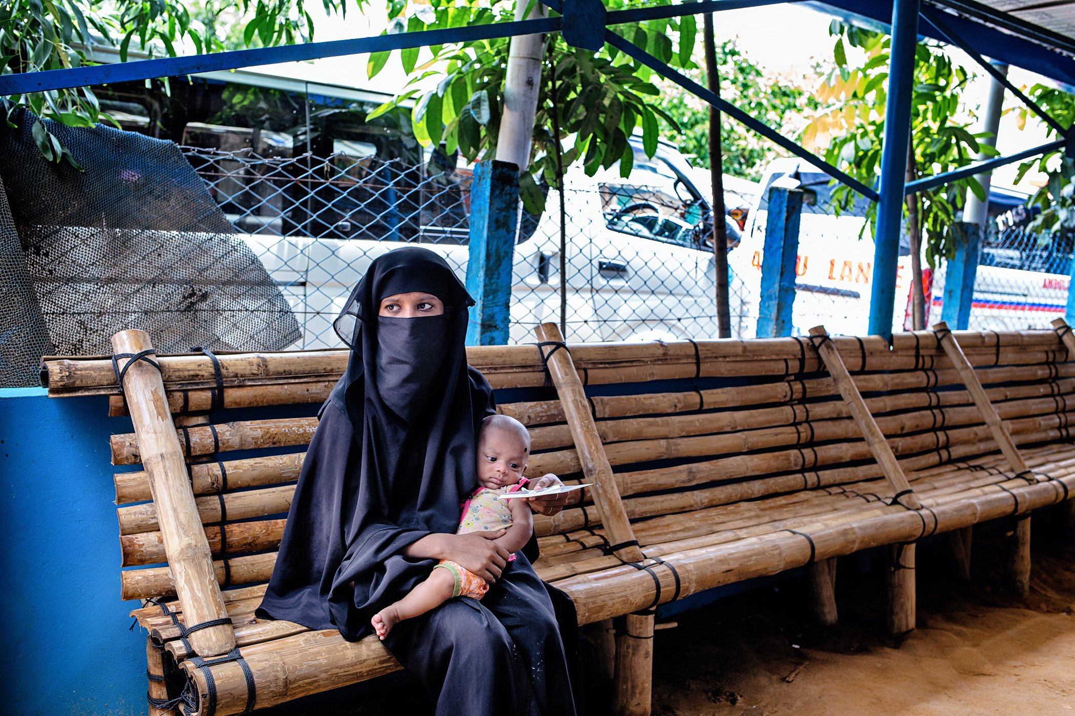 Nurresha waits with her child to take a COVID-19 test in a health care facility in a Rohingya camp in Cox's Bazar, Bangladesh, July 2020.