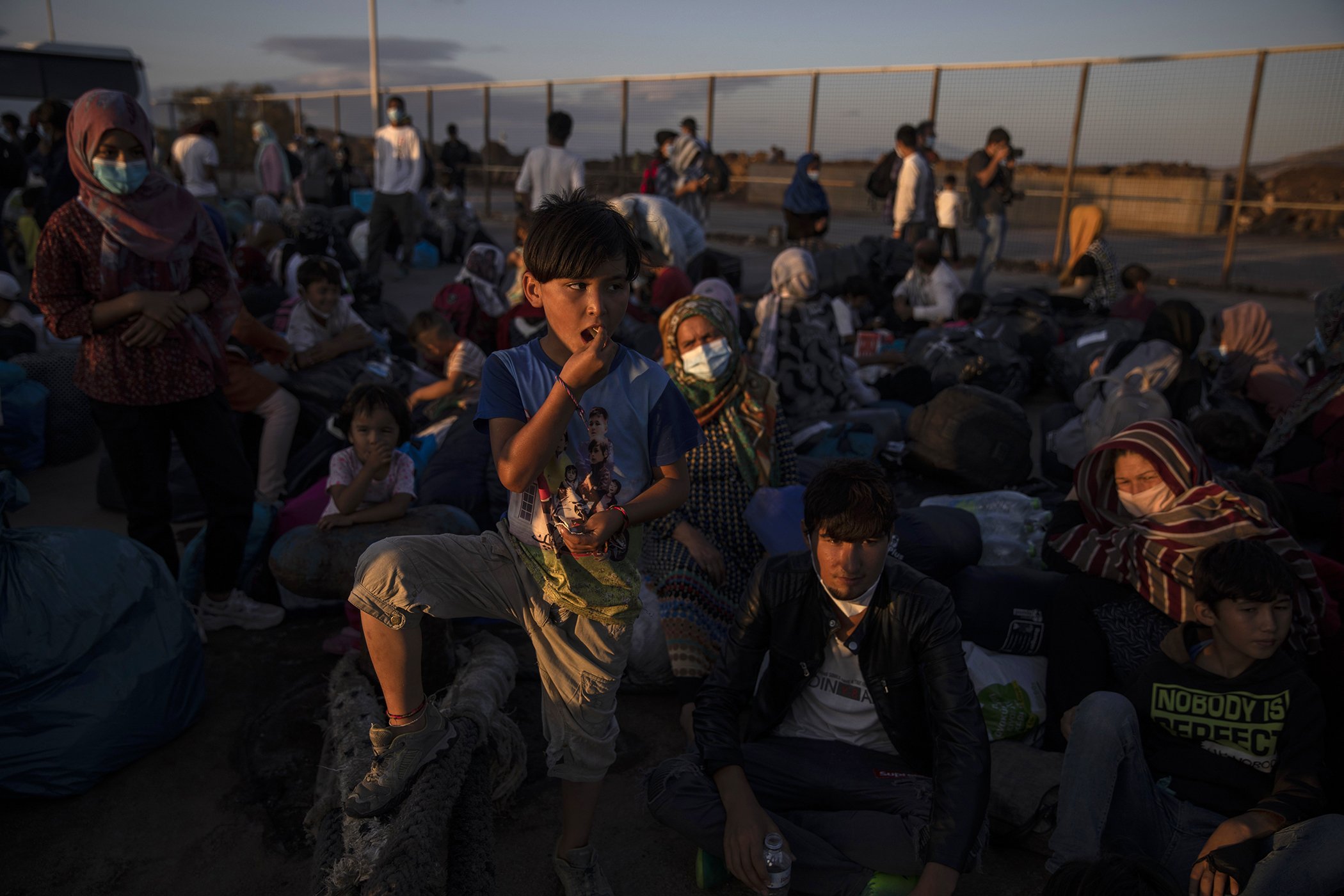 Migrants wait to board buses after their arrival at the port of Lavrio, south of Athens, Sept. 29, 2020. Greek authorities have moved nearly 1,000 asylum-seekers from eastern Aegean islands to the mainland as part of efforts to improve conditions.