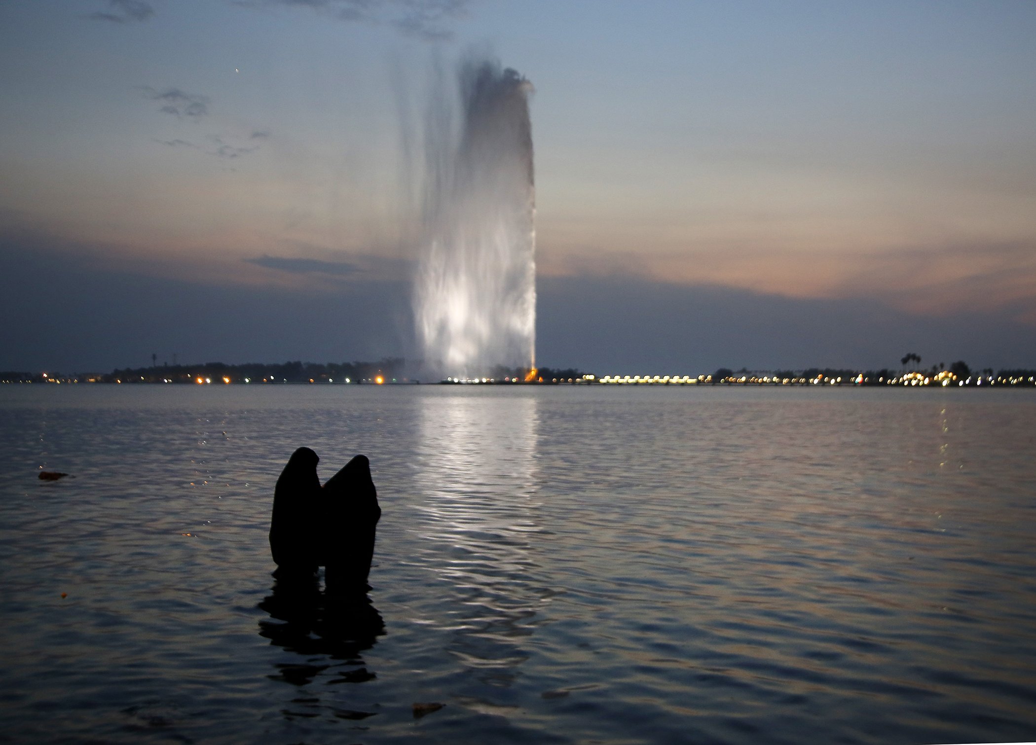 Women wearing the " Niqab" watch the landmark Jiddah fountain, in the Red Sea beach, in Jiddah, Saudi Arabia, Nov. 15, 2019.
