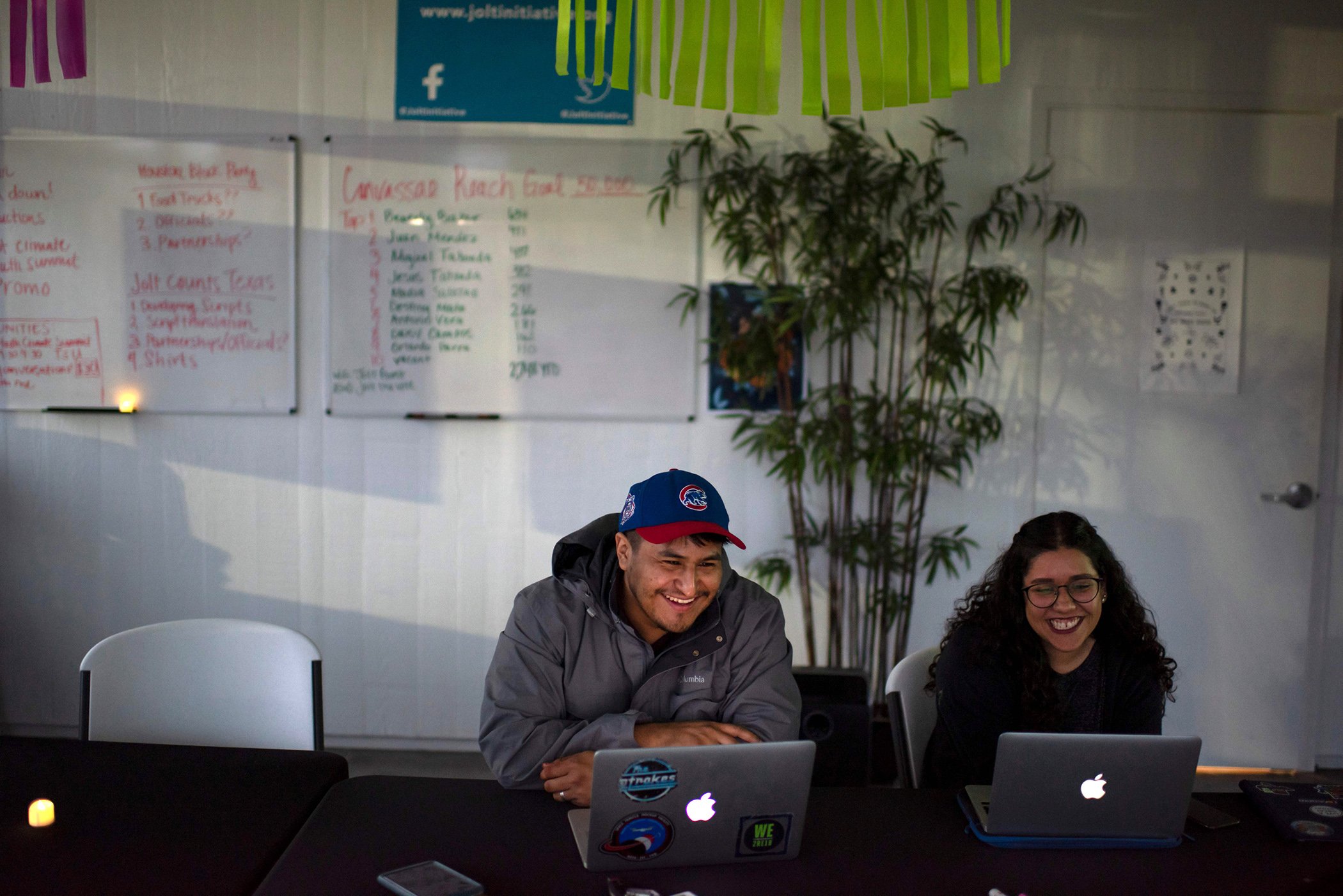 Victor Ibarra Jr. (L), 23, and Daisy Campos (R), 23, share a laugh during a volunteer meeting at the headquarters of Jolt, a non-profit organization that works to increase the civic participation of Latinos in Texas, in Houston, Texas on Feb. 20, 2020.