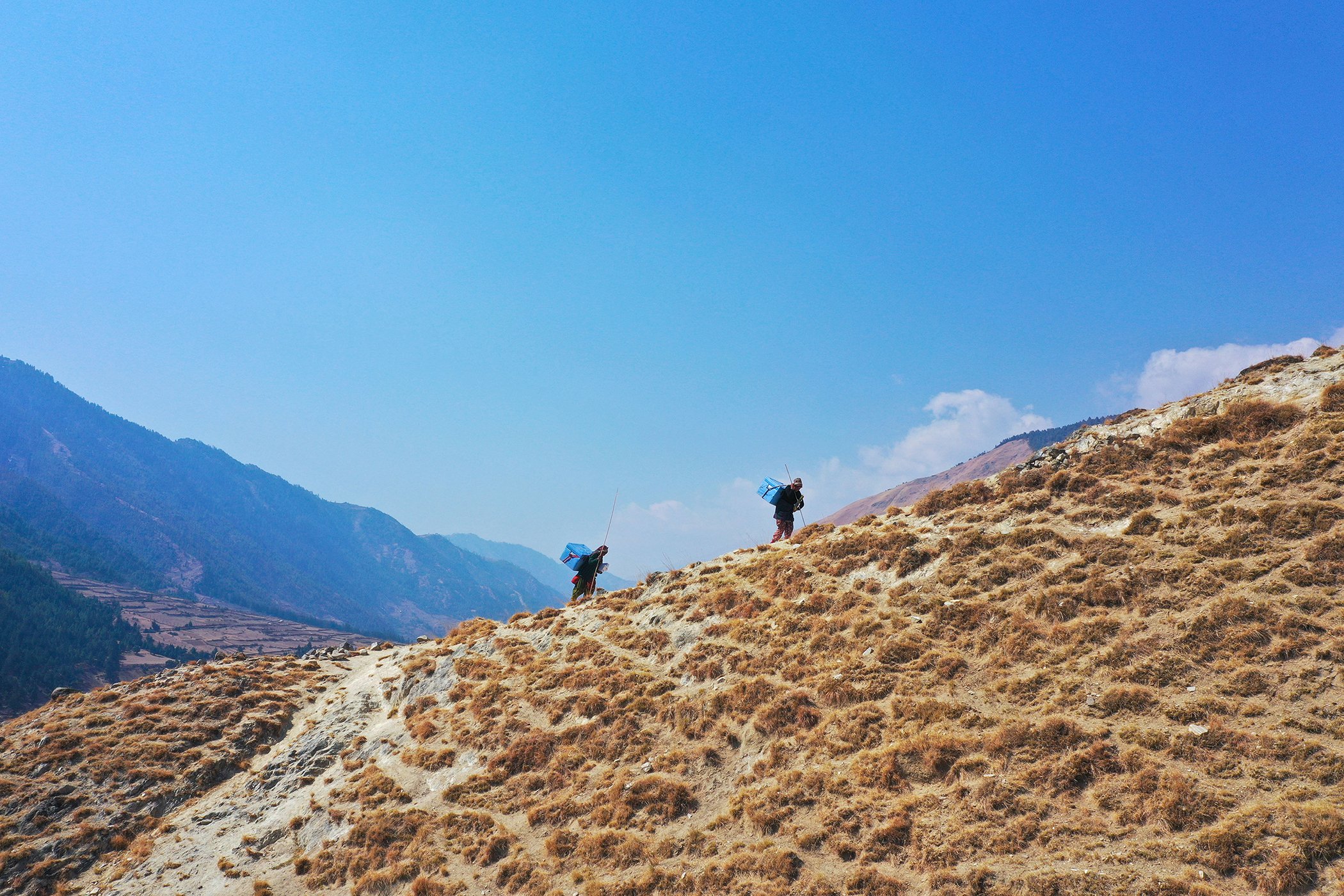 Porters carry COVID-19 vaccines to health facilities in Jumla District in Nepal’s remote far-west region on March 5, 2021.