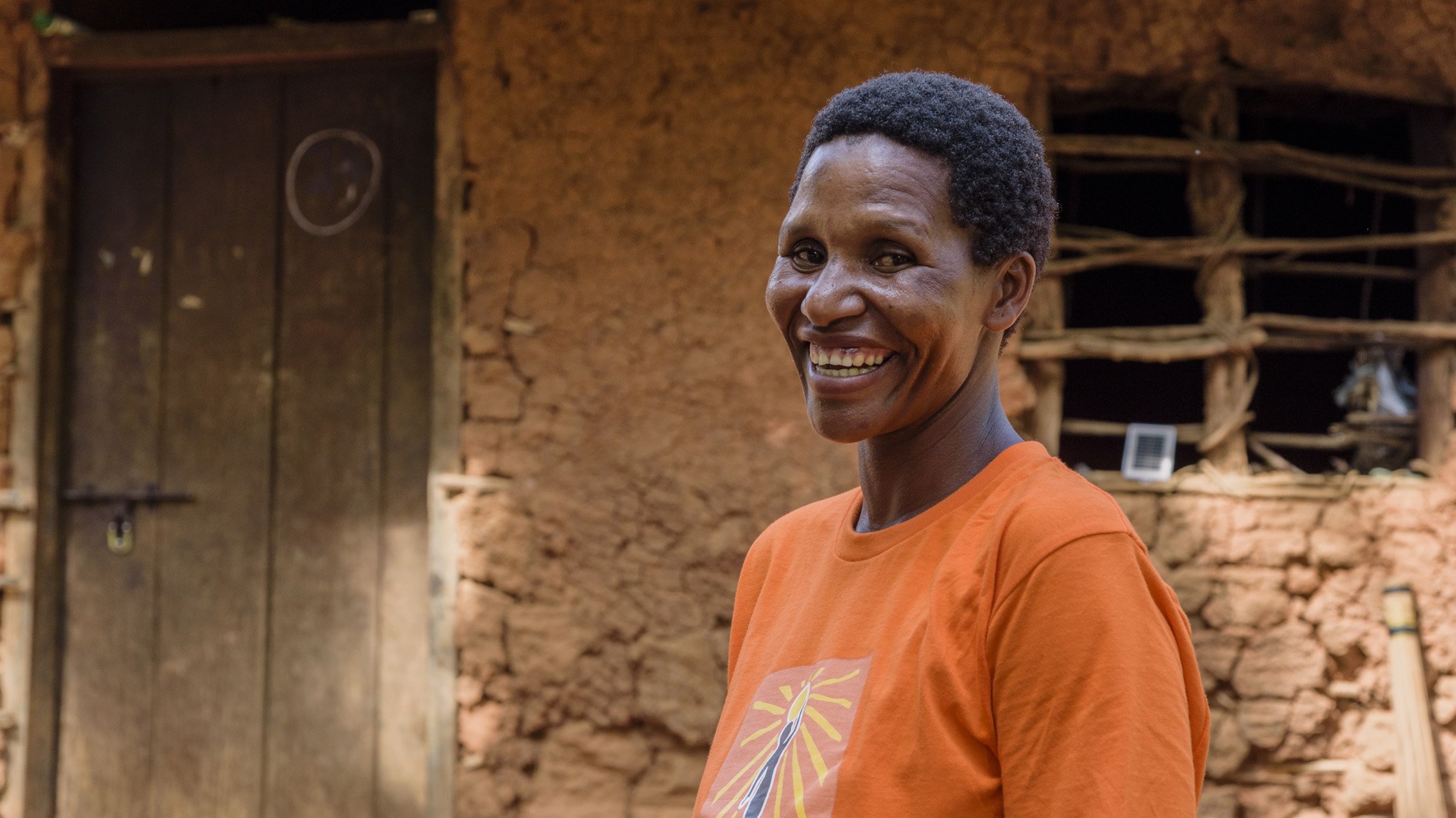 Angelina Majama, a successful entrepreneur with Cisco nonprofit partner Solar Sister, stands in front of her home in northeastern Tanzania.