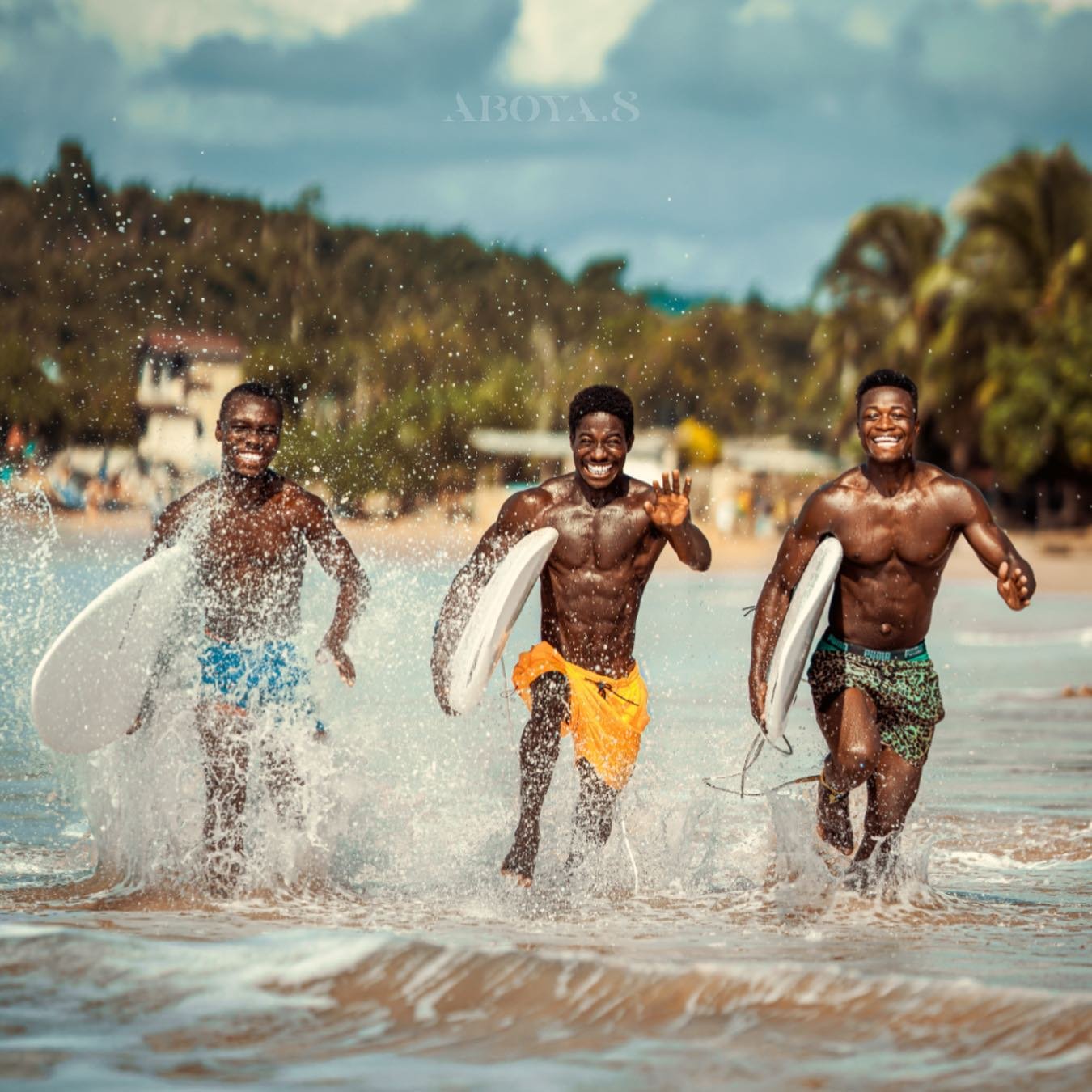 Justice's Brothers running on the shores of Busua Beach, getting ready to hit the waves.