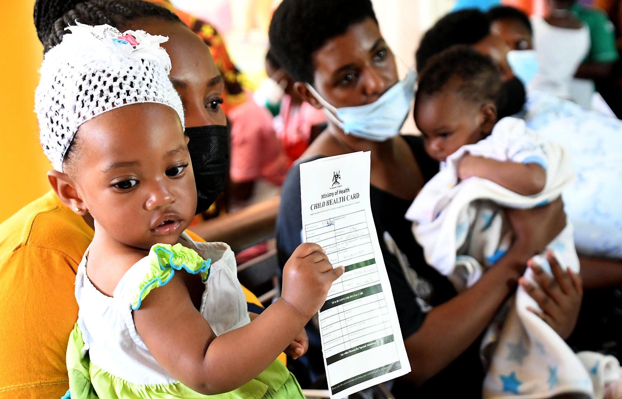 Agatha Nyakayisiki, who is 9months old, holds her child immunization card as she waits in the immunization queue at Fort Portal Regional Referral Hospital in Uganda in November 2021.