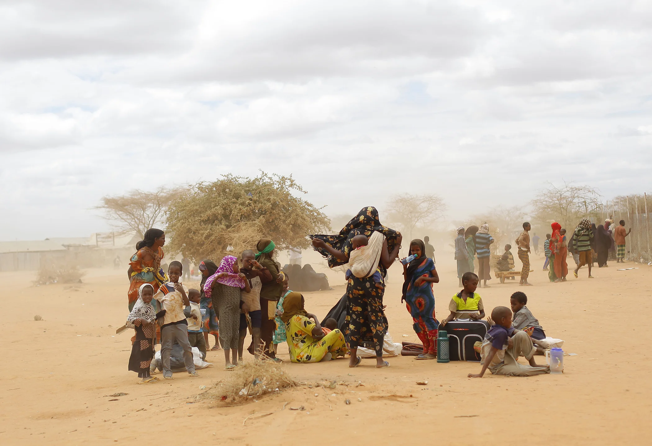 Newly arrived Somali refugees wait outside a UNHCR processing center at the Ifo refugee camp in eastern Kenya, Aug. 4, 2011. Climate change contributed to low rain levels in East Africa in 2011, making global warming one of the causes of Somalia's famine.